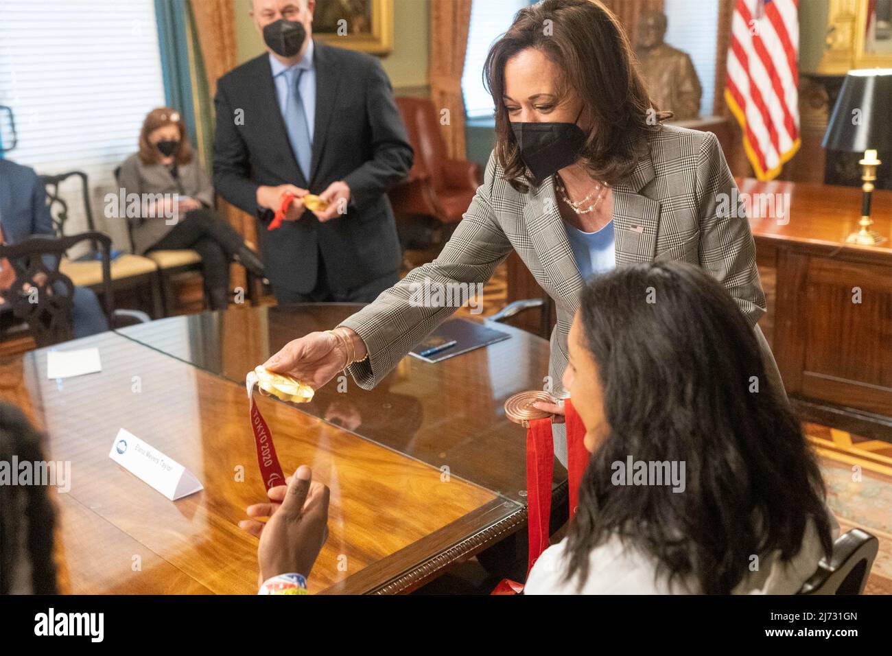 Washington, United States of America. 04 May, 2022. U.S Vice President Kamala Harris, center, views the gold medal of Olympia bobsled medalist before an event welcoming the athletes that participated in the Tokyo 2020 Summer Olympic and Paralympics, Beijing 2022 Winter Olympic and Paralympics, at the White House May 4, 2022 in Washington, D.C.  Credit: Lawrence Jackson/White House Photo/Alamy Live News Stock Photo