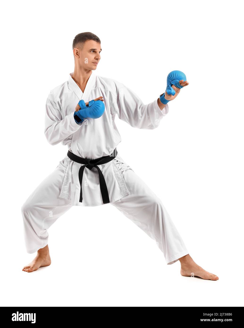 Man with black belt practicing karate on white background Stock Photo ...