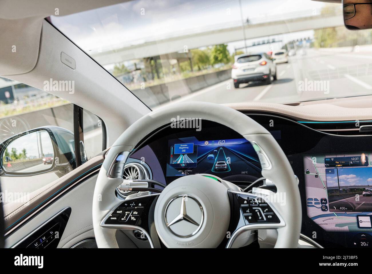 05 May 2022, Berlin: The steering wheel in a moving Mercedes of the ...