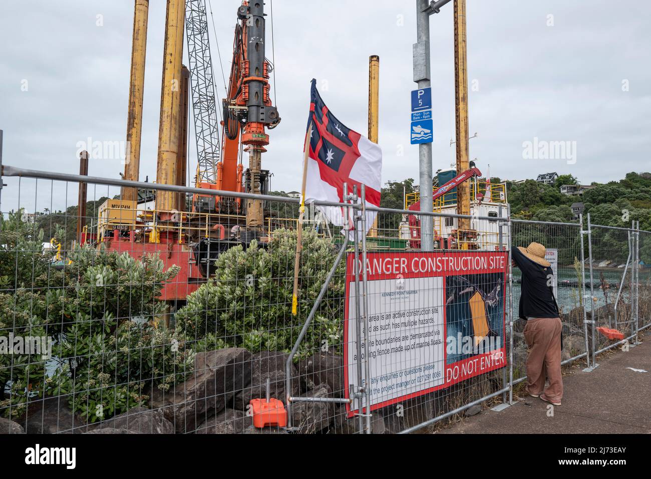A one man protest at sea works on Waiheke Island in the Hauraki gulf 30 mins from Auckland New Zealand. The flag is the original 1834 design for the f Stock Photo