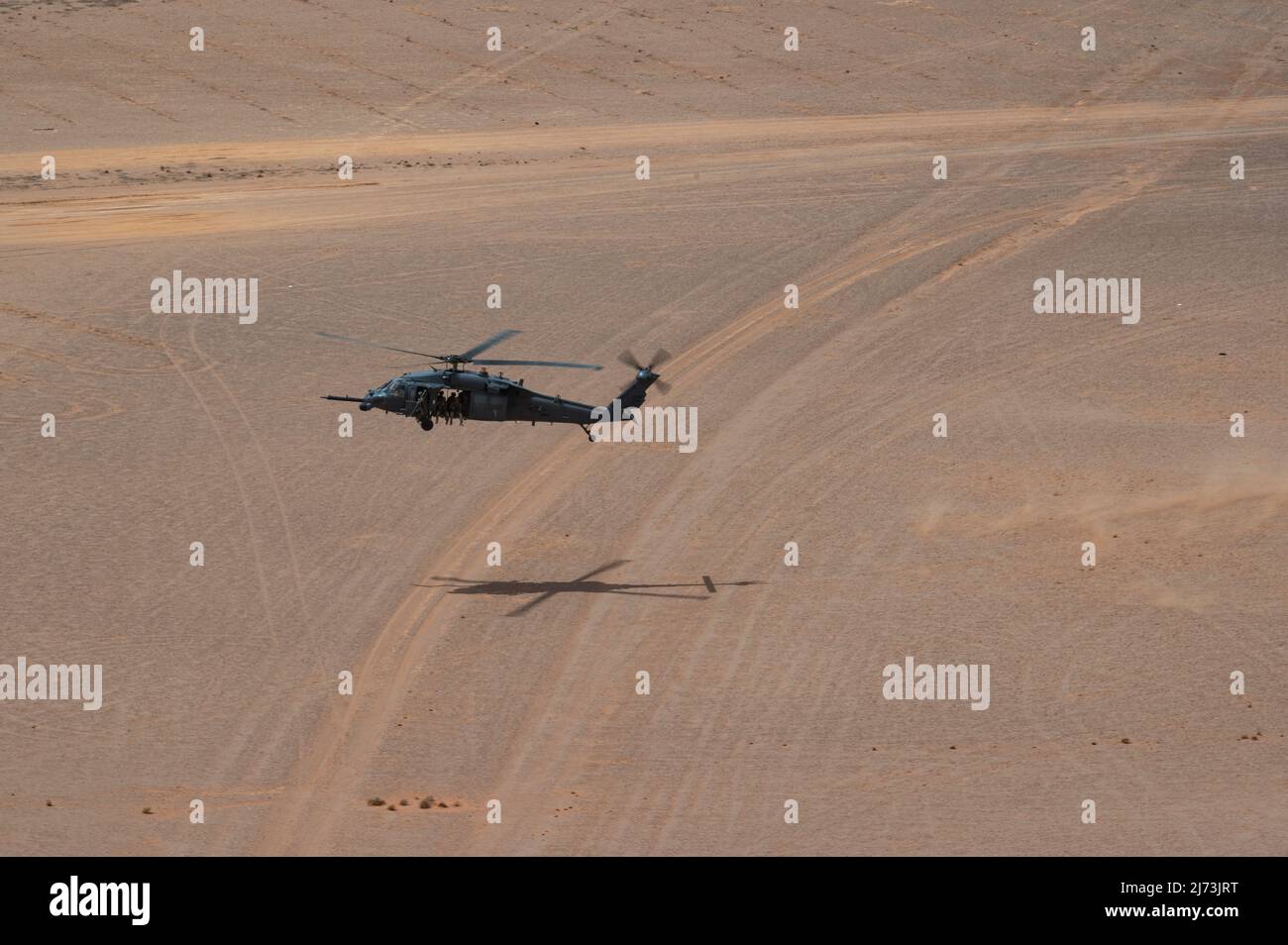 U.S. Air Force Pararescuemen, assigned to the 52nd Expeditionary Rescue Squadron, prepare to land at an undisclosed location for a combat search and rescue exercise in an HH-60 Pave Hawk, assigned to the 46th ERQSs, April 28, 2022. Air Forces Central Command's ERQSs are organized, trained, equipped, and postured to conduct full spectrum personnel recovery to include both conventional and unconventional combat rescue operations within the Central Command theater of operations. (U.S. Air Force photo by Staff Sgt. Christian Sullivan) Stock Photo