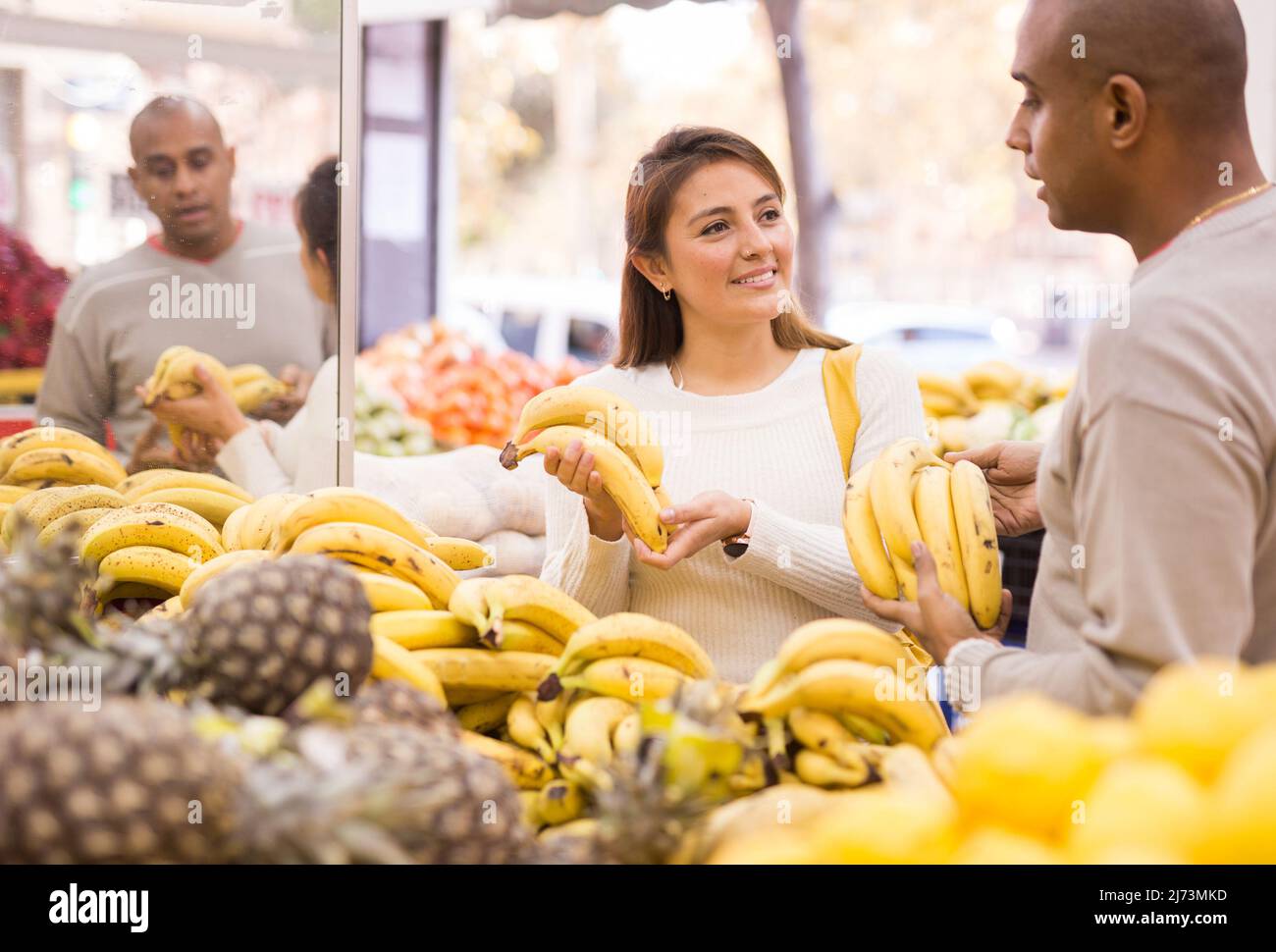 Married couple picks and buys ripe bananas in the vegetable section of