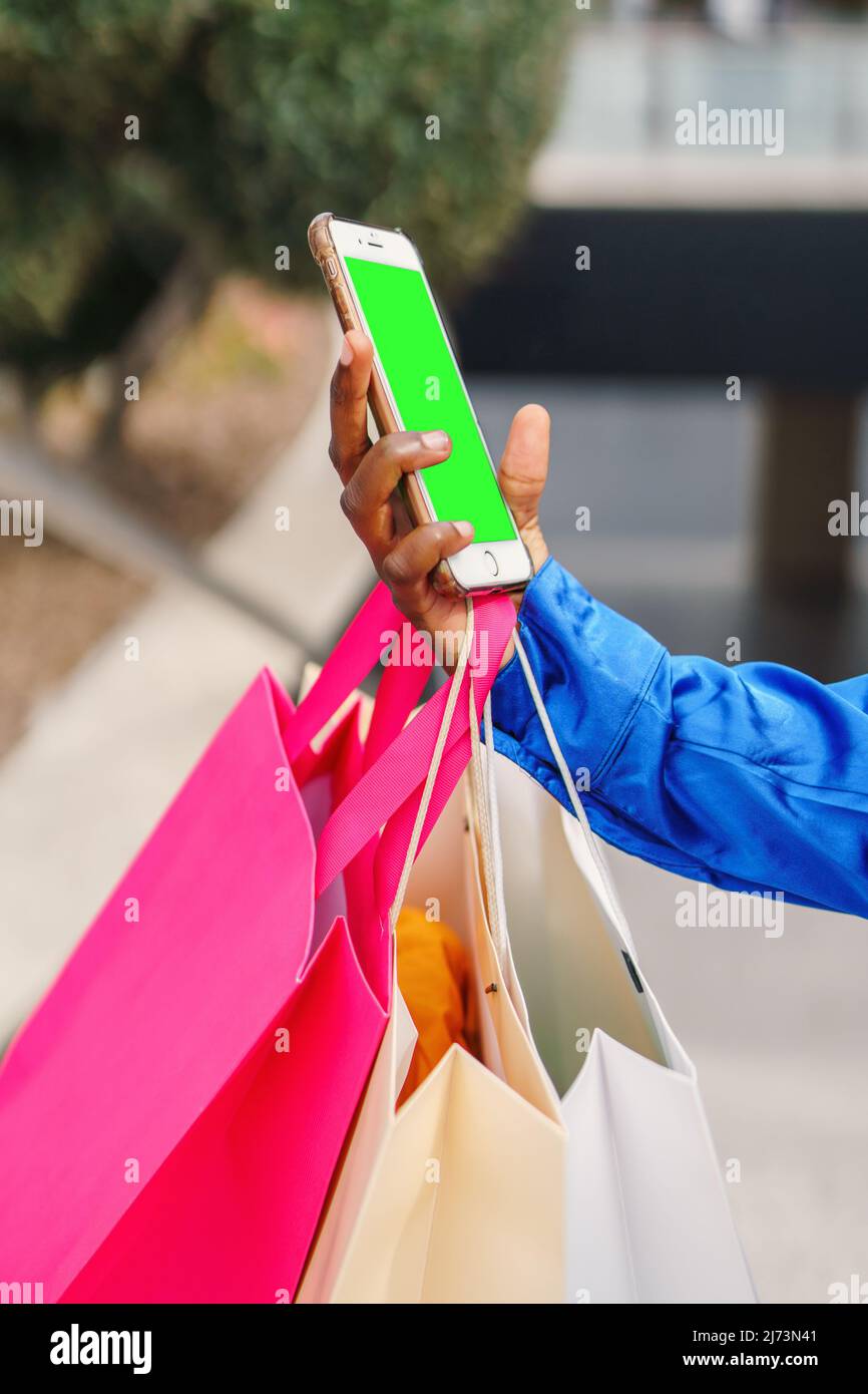 Crop black shopper using smartphone with green screen Stock Photo