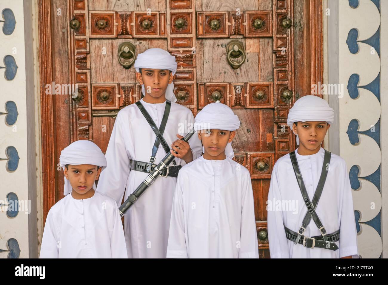 Four brothers in national dress, at the door of a restored house in the Sharjah Heritage Area, on their way to Sharjah's Heritage Days Festival. Stock Photo