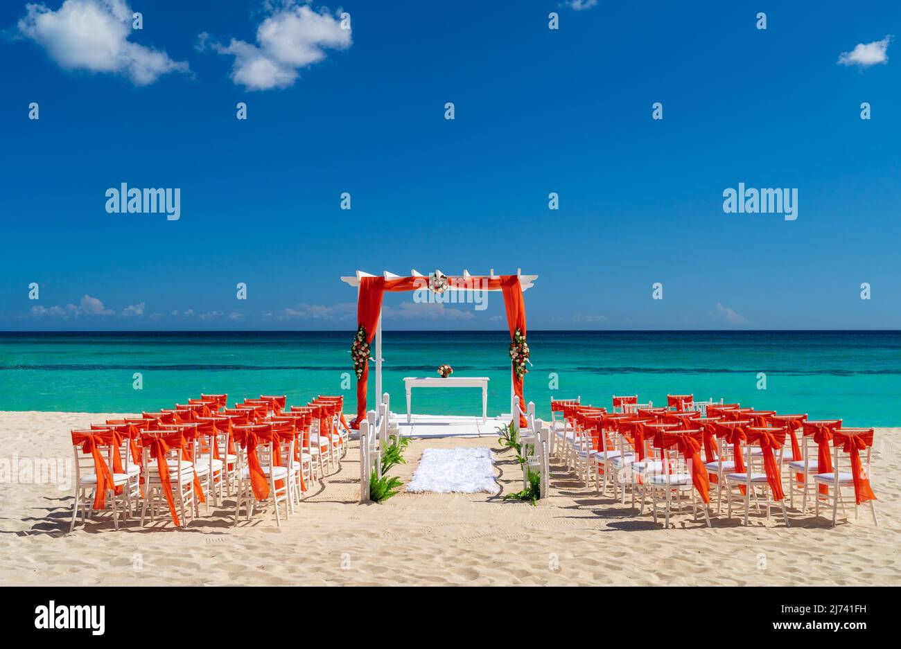 Romantic Wedding setting up with red decorations on the beach. Stock Photo