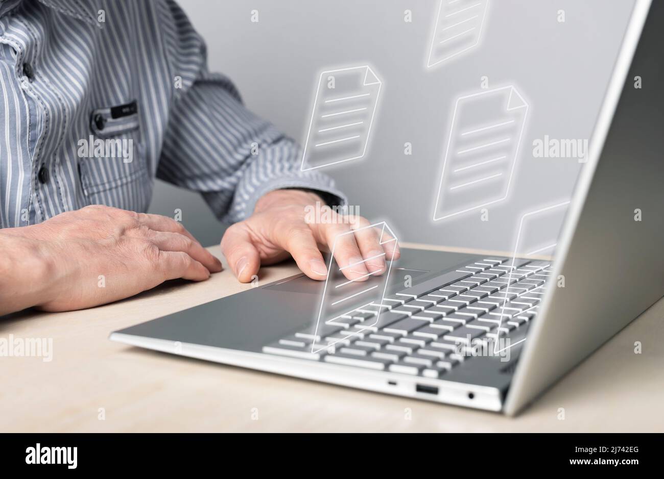 Businessman using laptop for electronic documents, letters sending and receiving. Man sitting at desk with computer. Online communication and paper flow concept. High quality photo Stock Photo