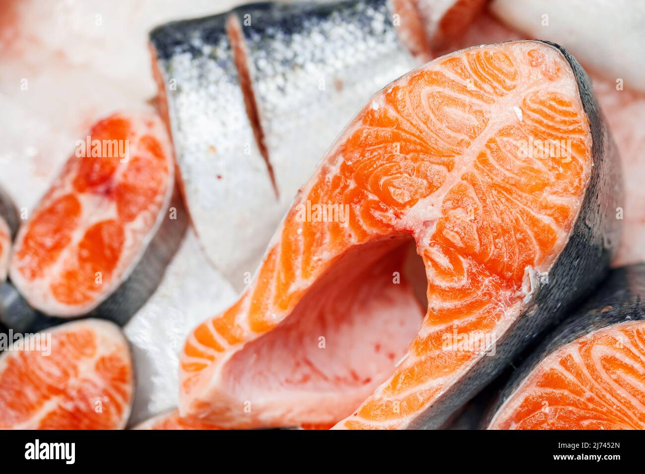 https://c8.alamy.com/comp/2J7452N/trout-cut-into-pieces-laid-out-on-ice-on-store-counter-pieces-of-red-fish-in-close-up-2J7452N.jpg