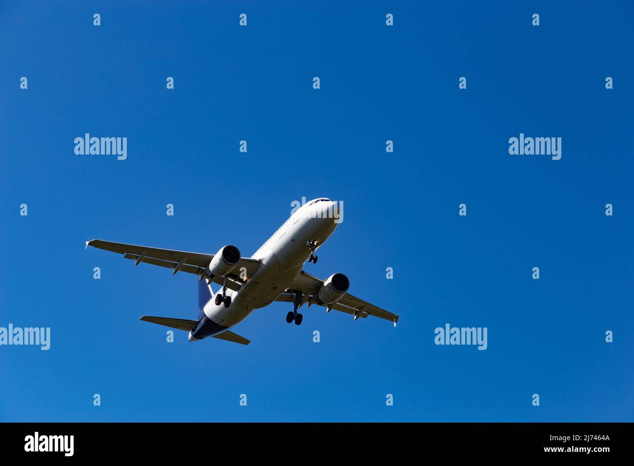 Airplane flying on the blue sky background Stock Photo - Alamy