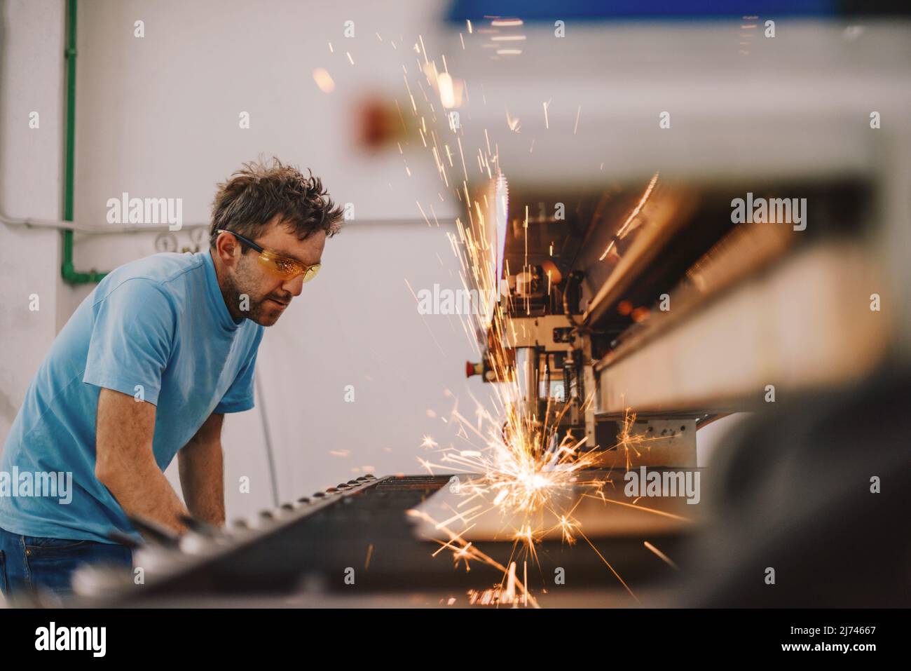 Within heavy industry. A man works in a modern factory on a CNC machine ...