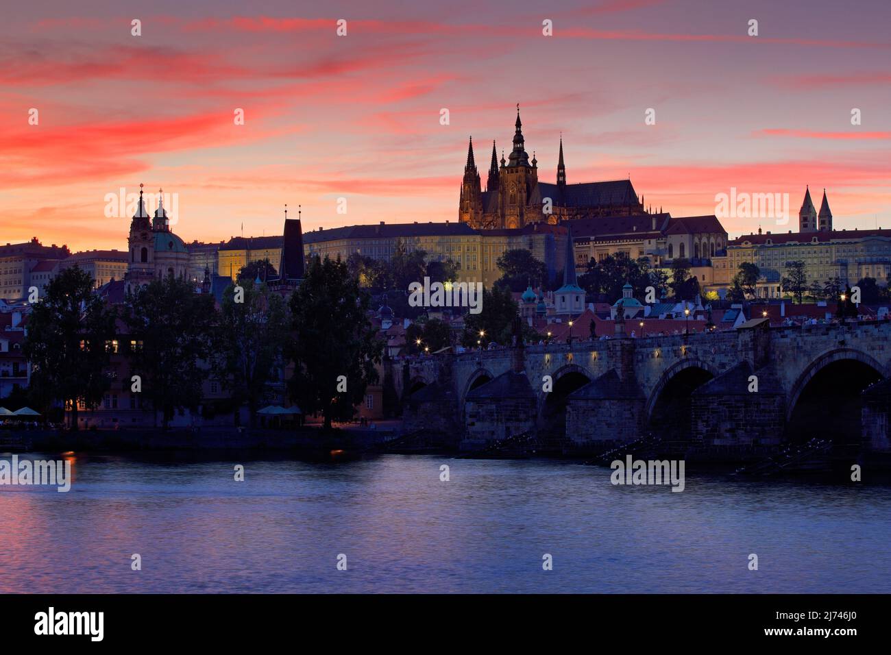The Prague Castle, gothic style, largest ancient castle in the world and Charles Bridge, built in medieval times, moving boats, Twilight view of Pragu Stock Photo