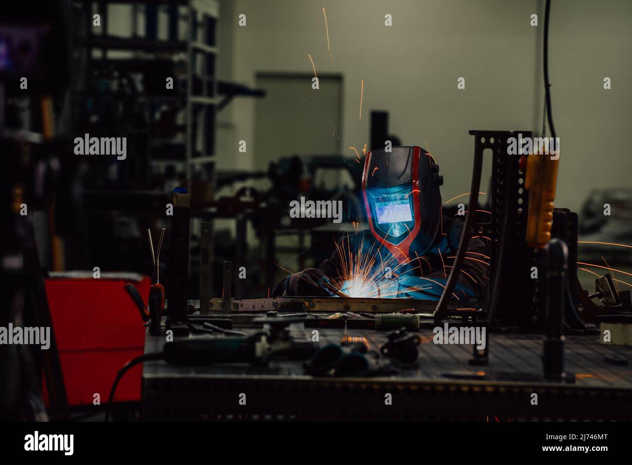 Professional Heavy Industry Welder Working Inside factory, Wears Helmet