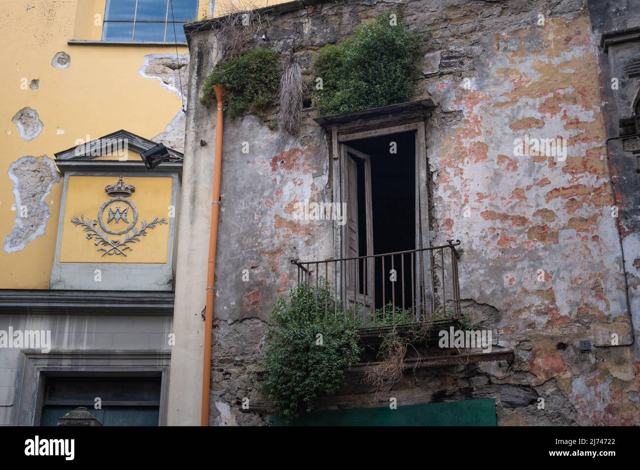 Broken balcony door of old building in the center of Naples Stock Photo