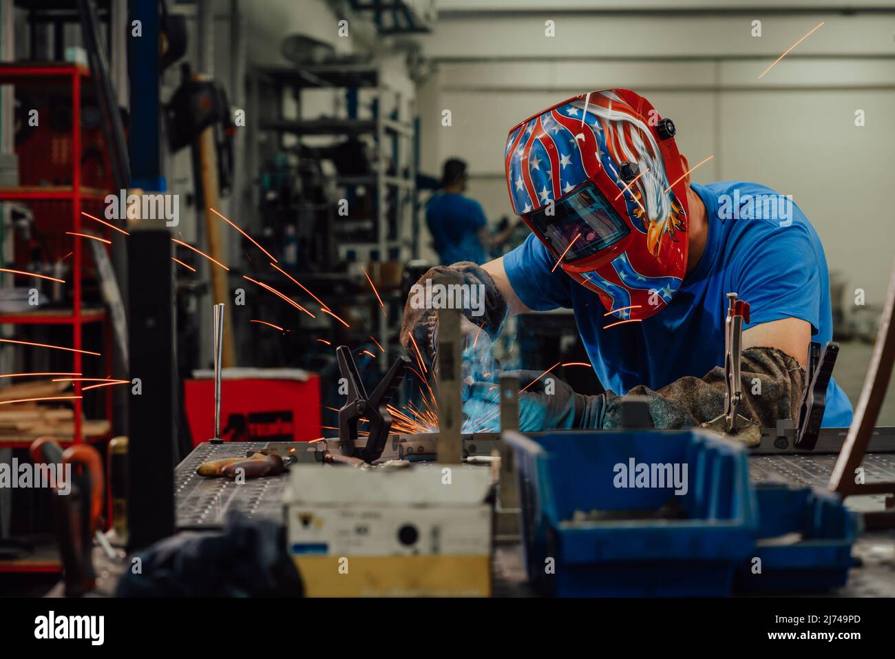 Professional Heavy Industry Welder Working Inside factory, Wears Helmet