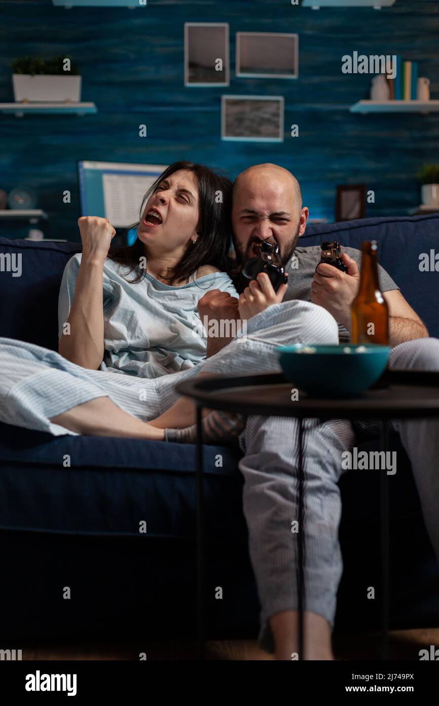 Irritated man and woman losing online videogames challenge on television console, feeling frustrated about lost gaming competition. Angry couple using cyberspace for leisure activity. Stock Photo