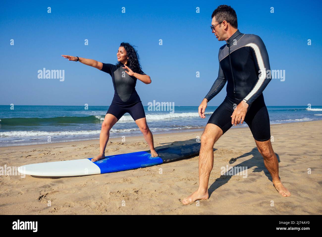 man instructor demonstrating how to stand up on surfboard to indian