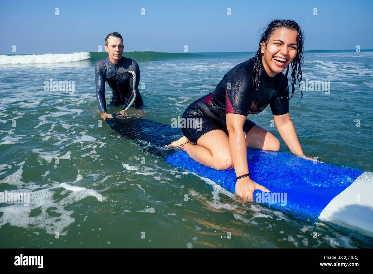man instructor demonstrating how to stand up on surfboard to indian