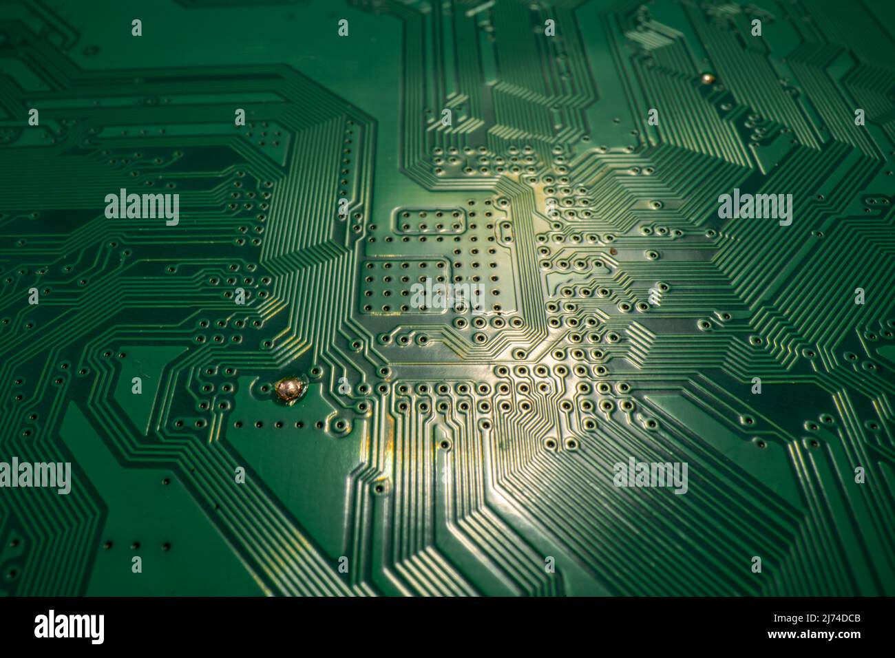 Circuit board. Technological electronic plate with roads and other components, selective focus. Technology background, electronics texture. Stock Photo