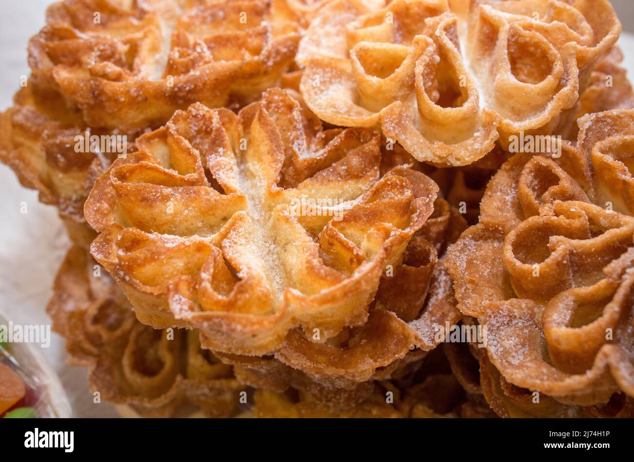 Platter full of traditional fried flores or flowers. Spanish fritter dusted with sugar Stock Photo