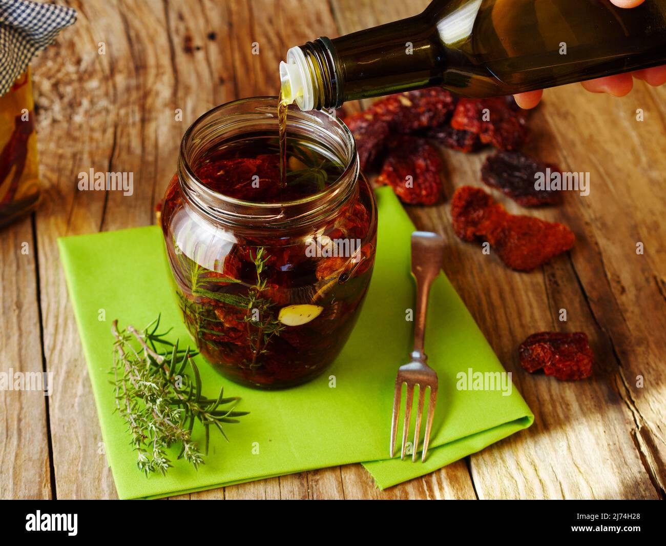 how to preserve sun dried tomatoes in a jar; person filling native olive oil Stock Photo Alamy