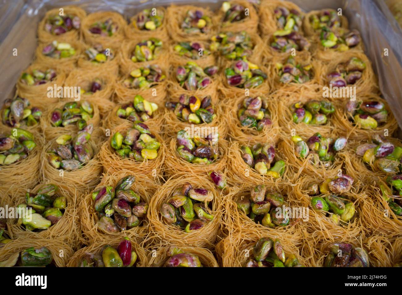 Platter crammed with Nightingales Nests or Ouch El Boulboul. Arabic dessert with pistachio Stock Photo
