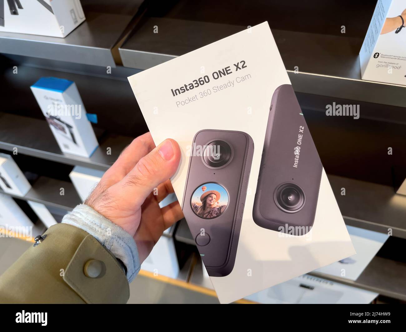 Paris, France - Mar 18, 2022: POV male hand holding new Insta360 one x2 pocket 260 steady cam camera at the Apple Inc. flagship store Stock Photo