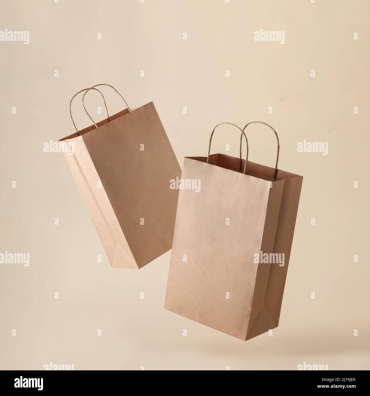 Two paper bags in a container levitation on a clean beige background for shopping in a store and selling food products or marketing as well as for del Stock Photo