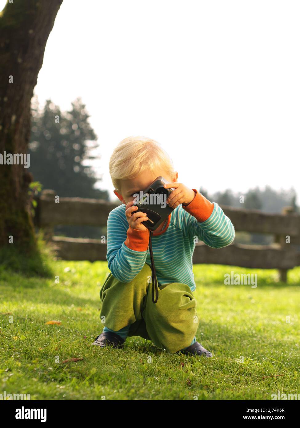 kind, 3 jahre alt, beim fotografieren im garten Stock Photo