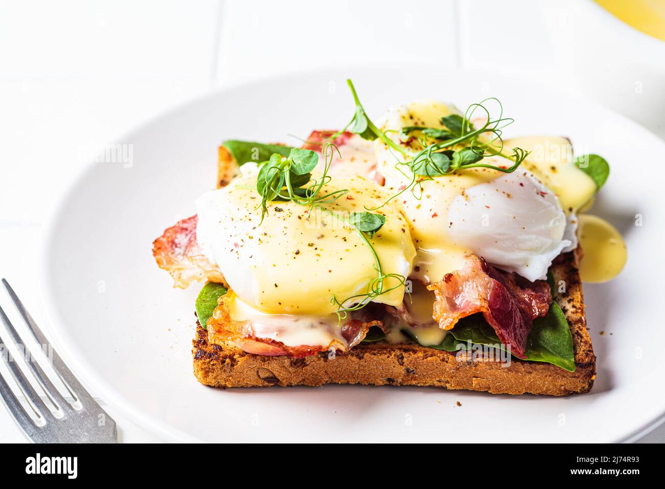 Eggs benedict on crispy toast with bacon and traditional hollandaise