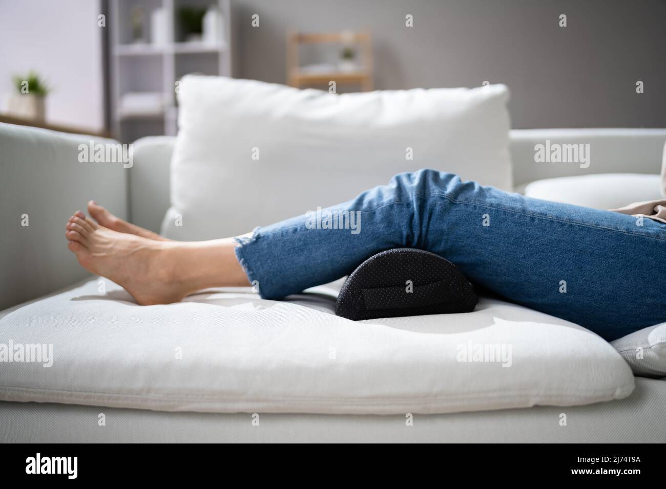 Woman Using Footrest To Reduce Back Strain And Feet Fatigue Stock Photo