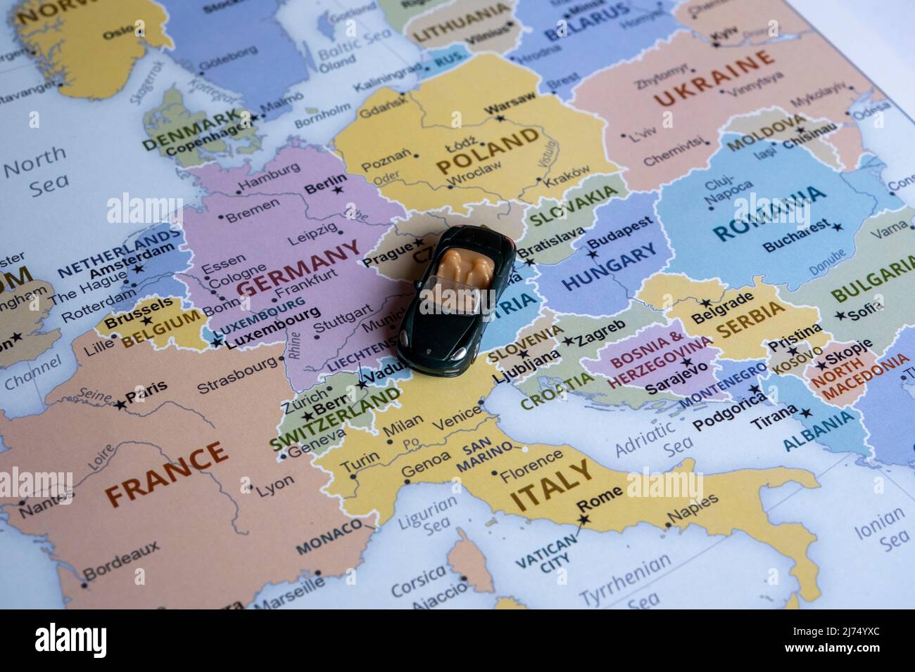 Toy car on Europe map, side view, world trip concept, miniature green sport car going to Italy, country and Europe tour Stock Photo