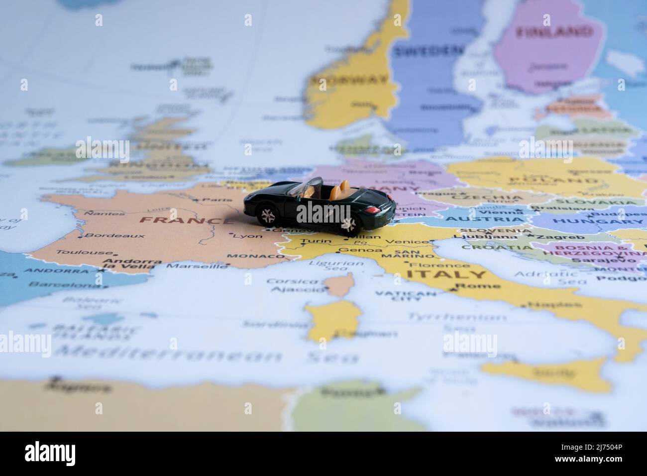 Toy car on Europe map, sitting view, travel concept, miniature green sport car going to France, worldwide tour, Europe map idea Stock Photo