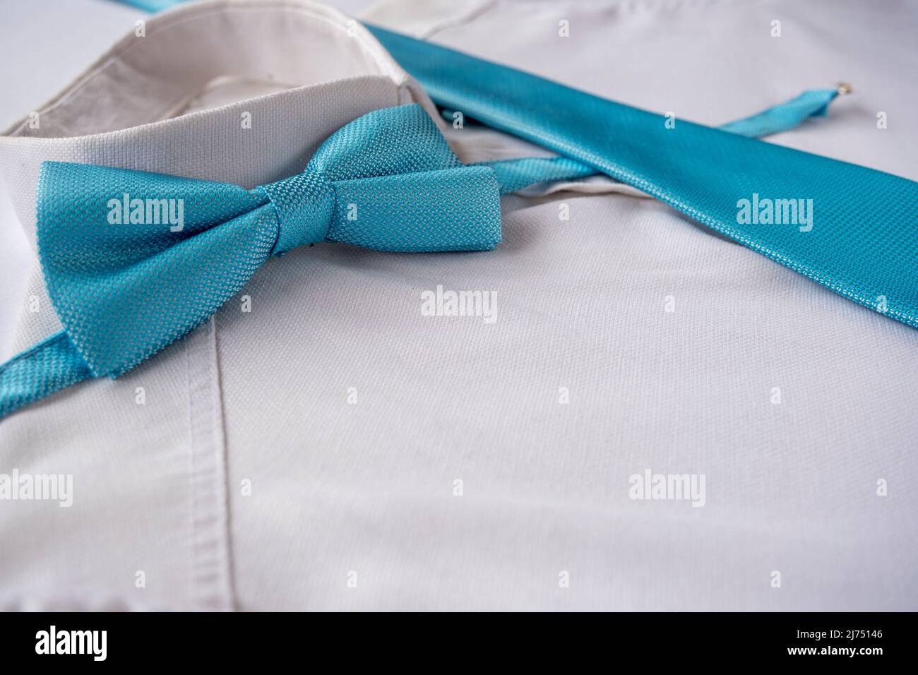 Blue tie and bow tie on white shirt, men fashion concept, blue color accessories,  men clothing idea, sitting view Stock Photo