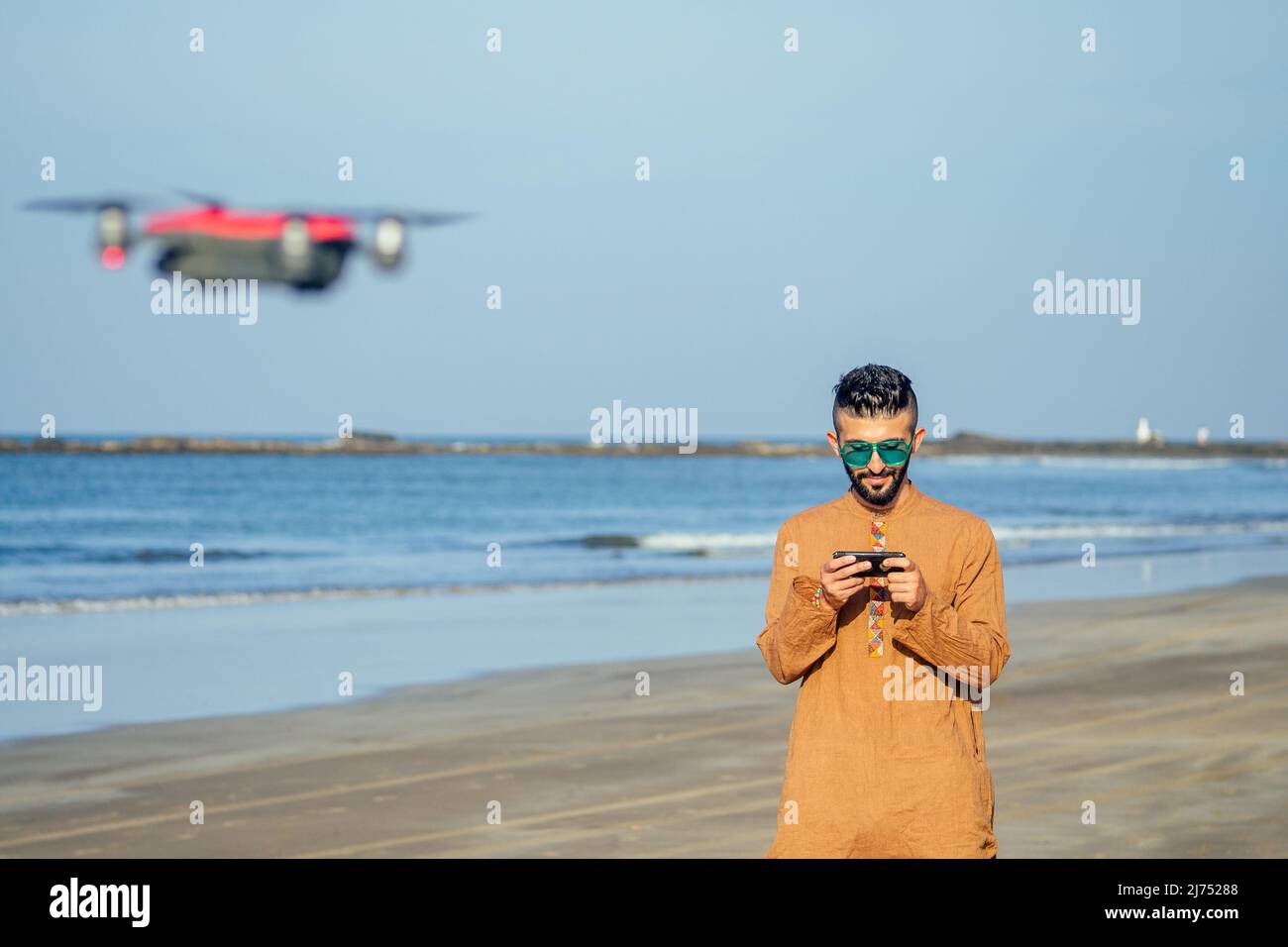 arabian man testing a drone photo and video shooting on quadrocopter over  the sea in Goa beach Stock Photo - Alamy