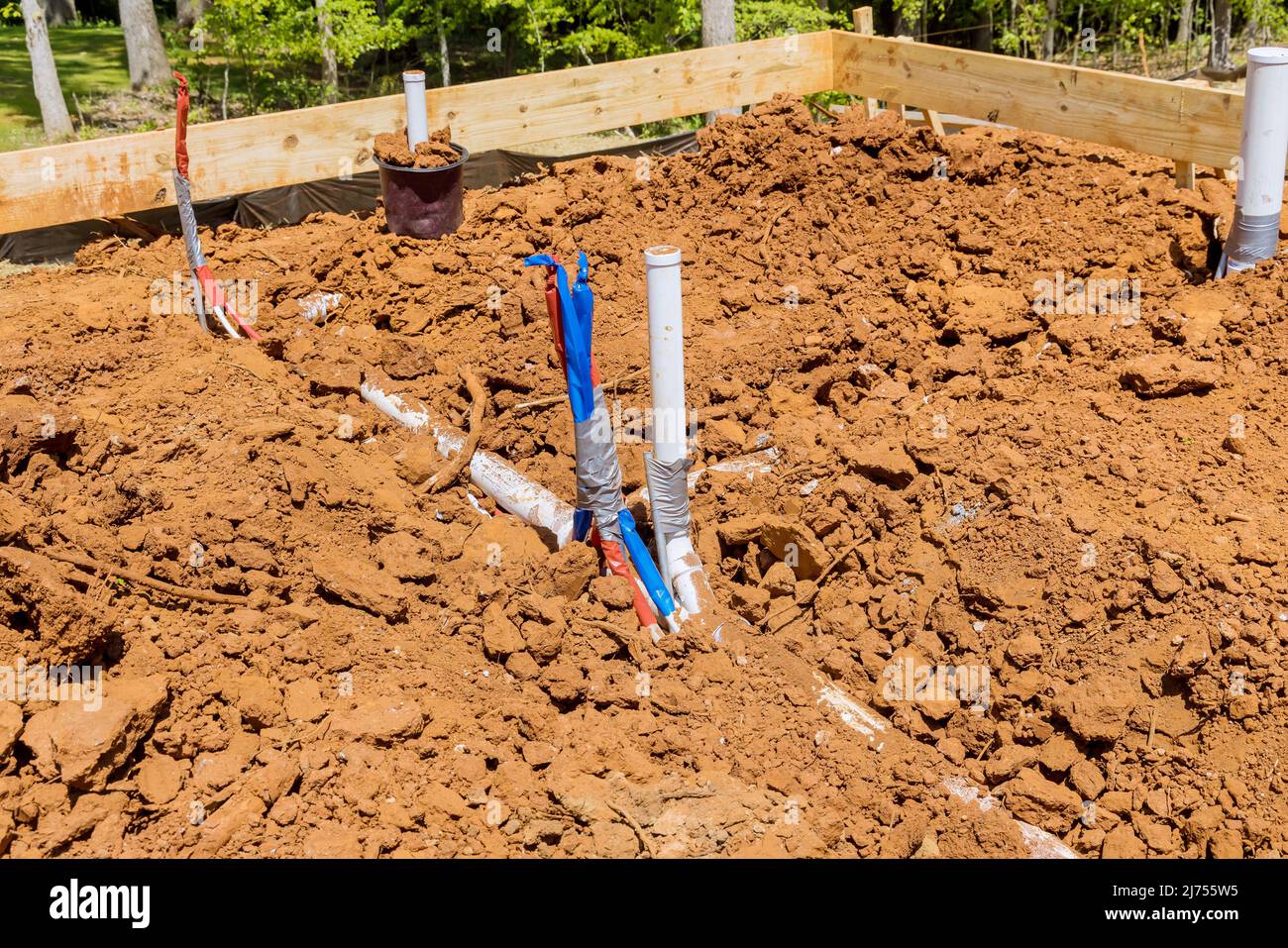 Laying sanitary pvc sewage pipes and water pipe system in trench Stock