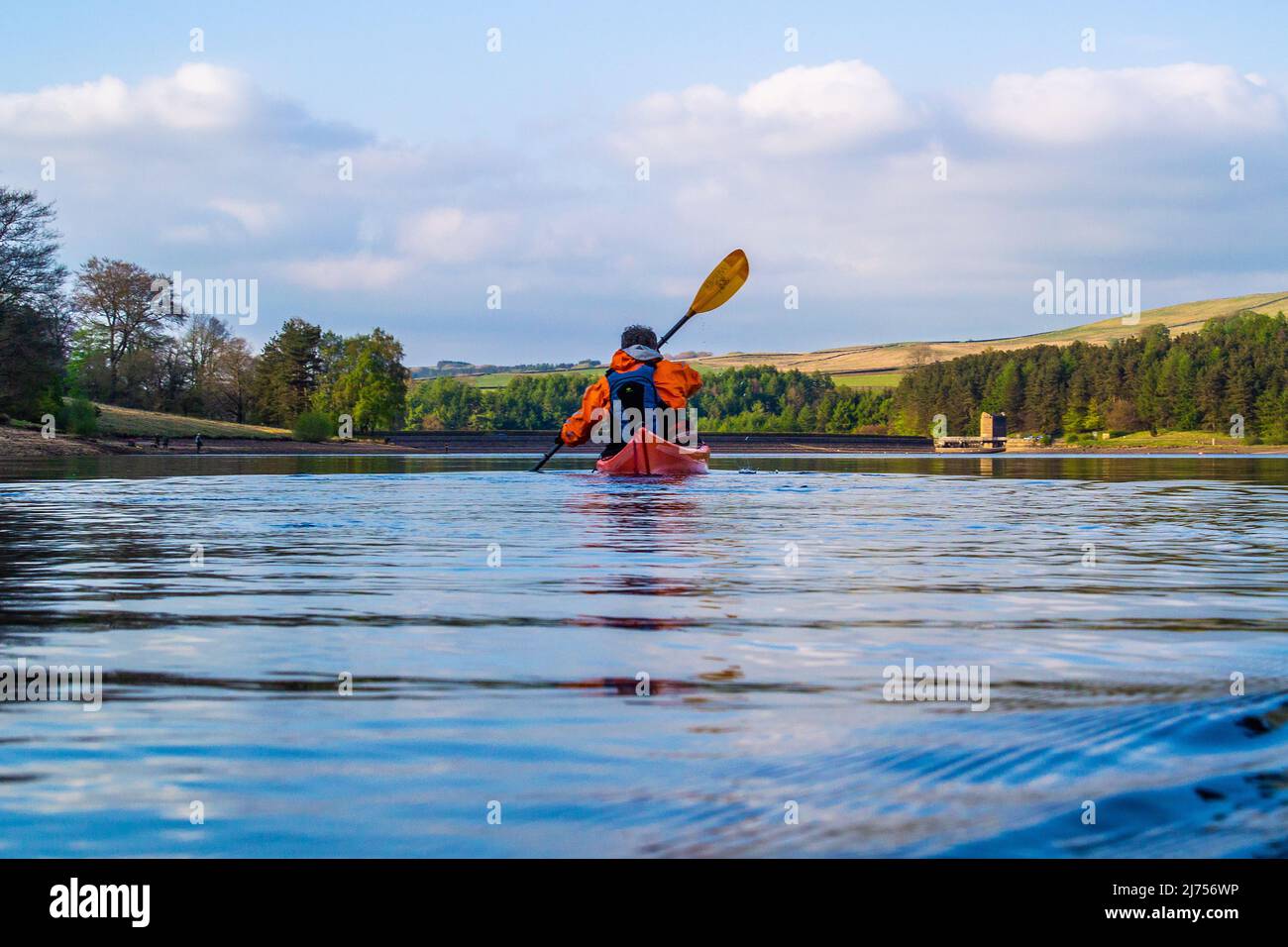 A kayaker paddling on Errwood reservoir in the Peak District Stock Photo