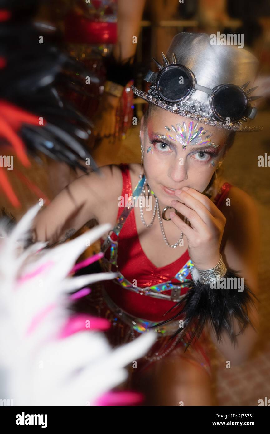 Sitges Carnival in Spain: close-up on a young woman in fancy dress staring at the camera with a curious expression. Stock Photo