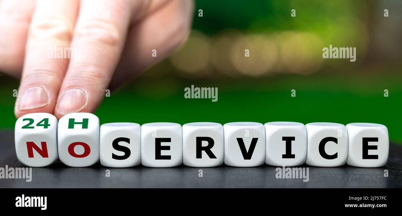 Hand turns dice and changes the expression 'no service' to '24h service'. Stock Photo