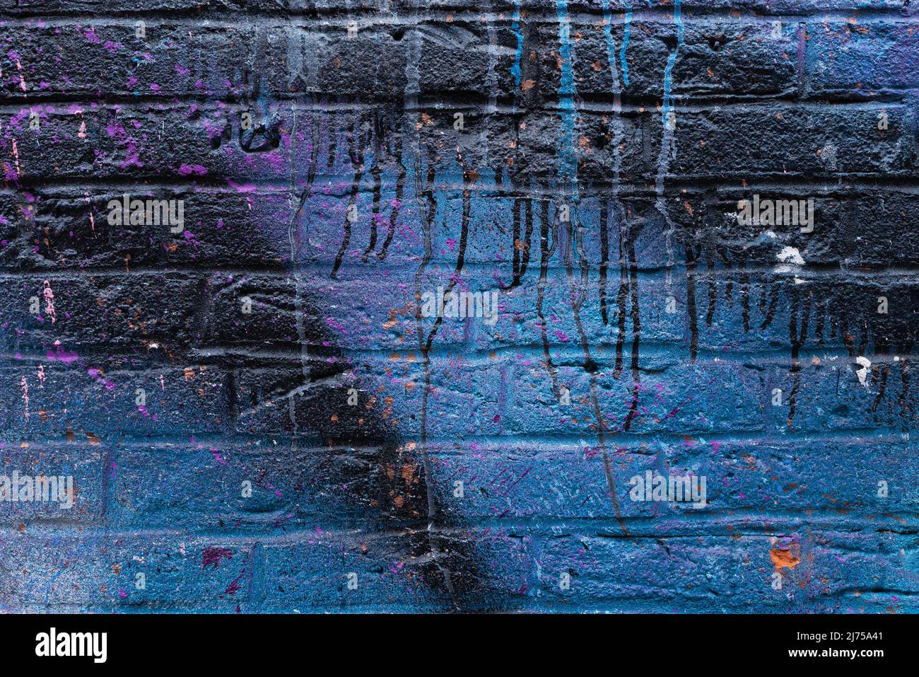 Colorful painted brick wall in city alley. Stock Photo