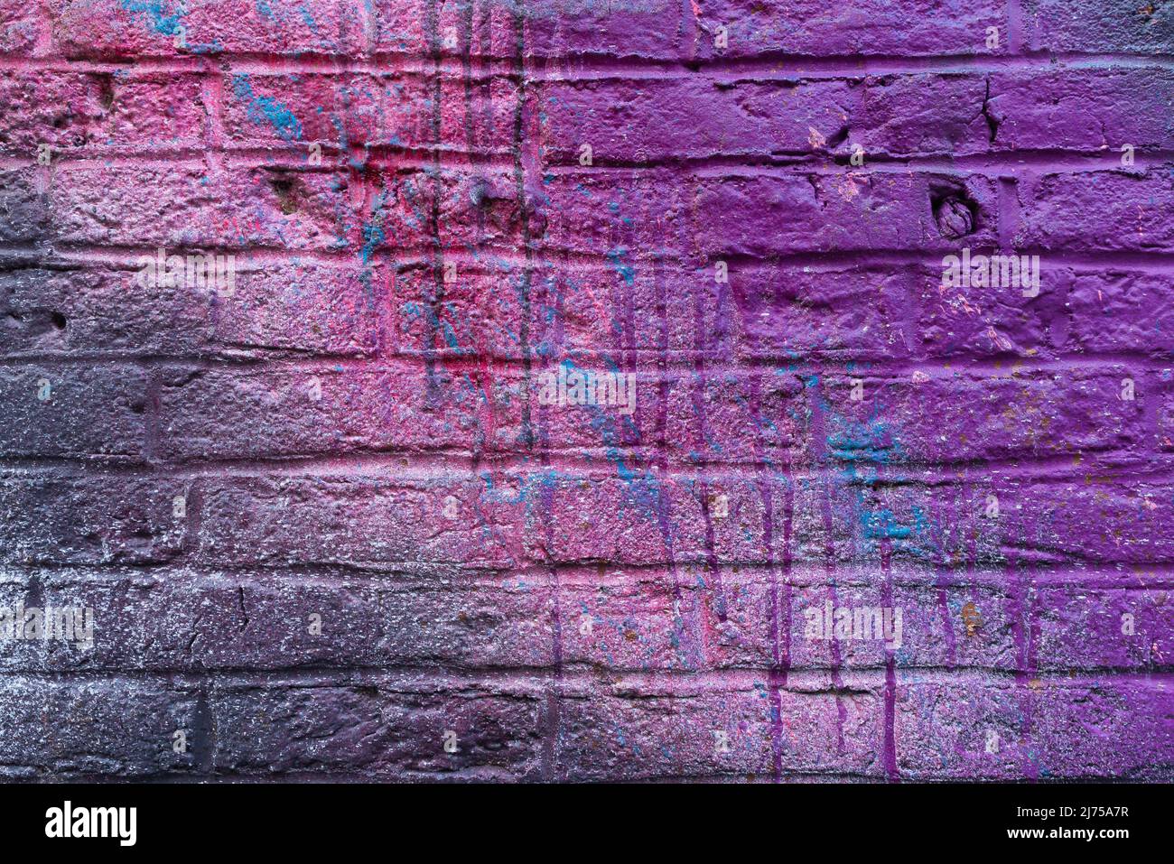 Colorful painted brick wall in city alley. Stock Photo