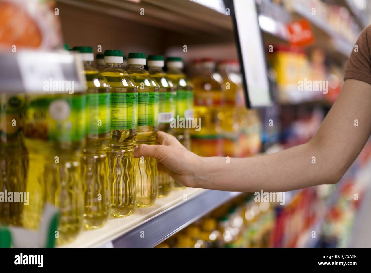 Woman buying cooking oil in supermarket, close-up Stock Photo