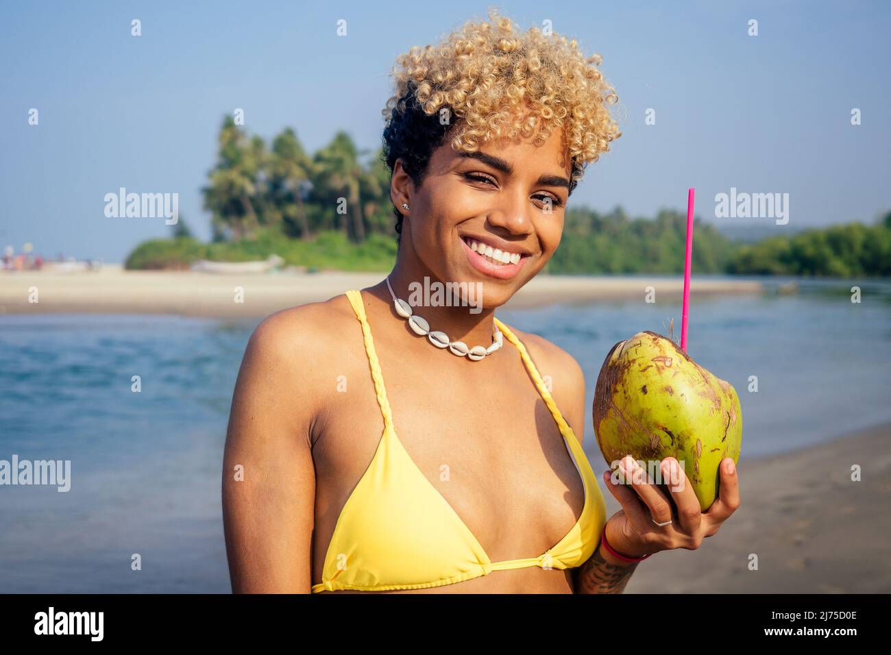 hispanic latin beautiful female drinking coco nut water seashells on the neck Stock Photo