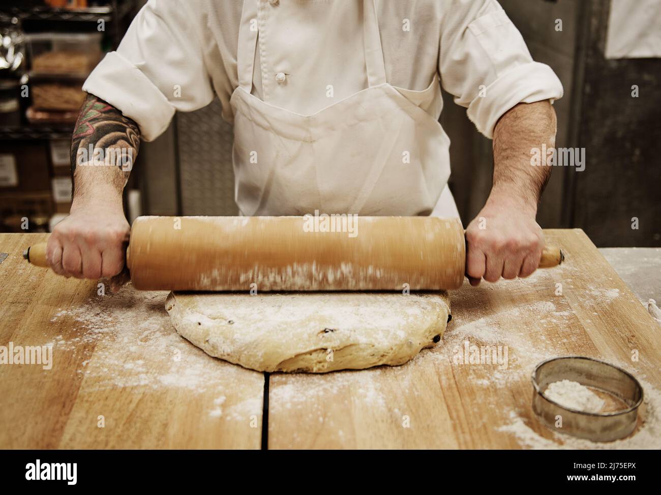 A baker rolling dough in a bakery Stock Photo Alamy