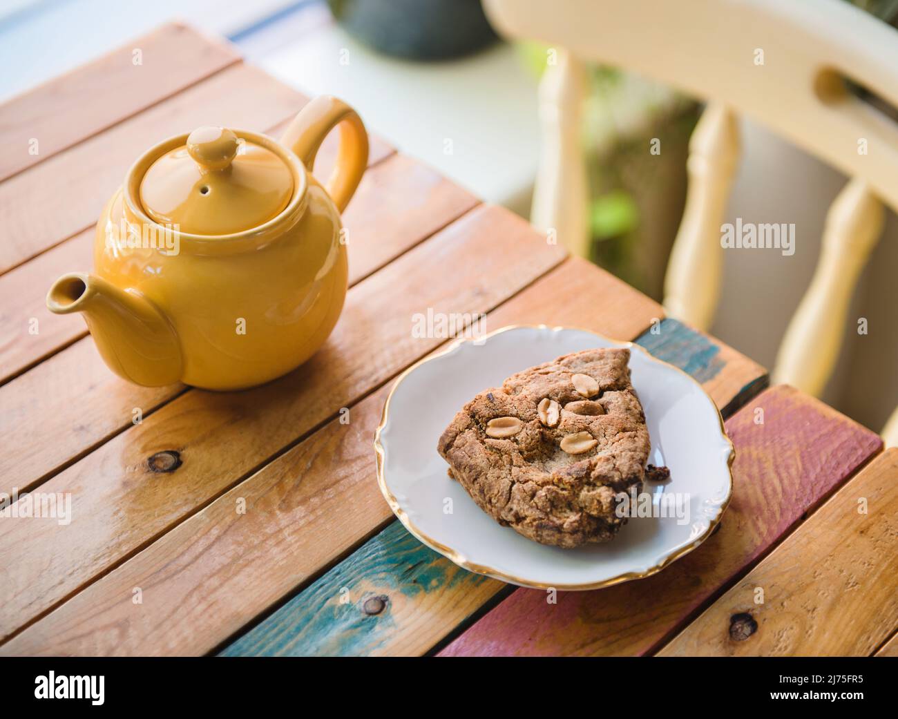 A pot of tea with an almond pastry on a wooden table Stock Photo