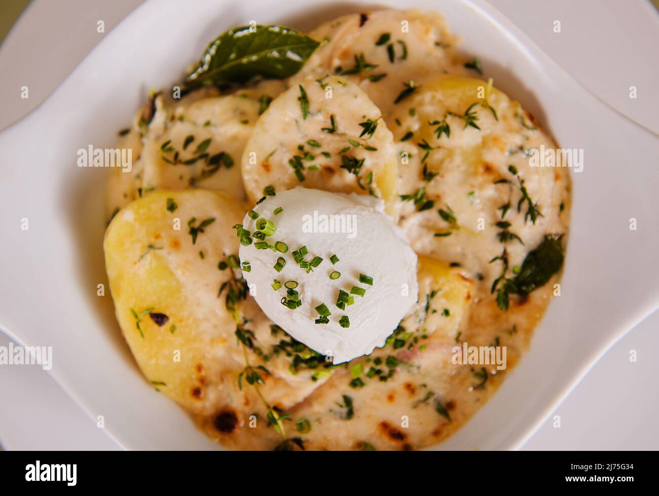 French Brunch of Tartiflette with a poached egg, potatoes and chives Stock Photo