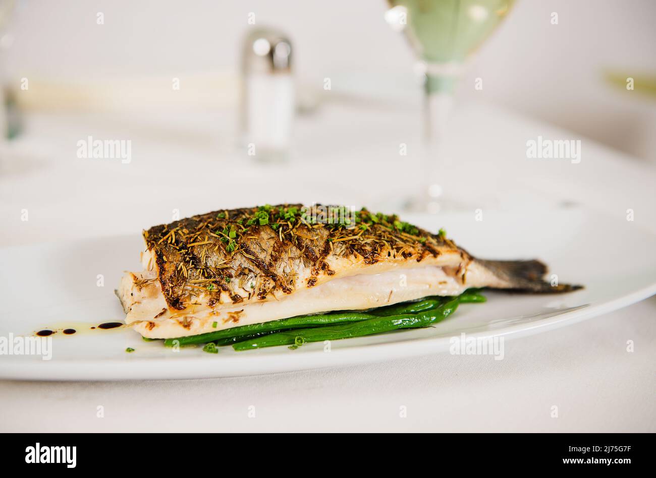 Grilled fish with herbes de Provence and fresh sliced chives Stock Photo