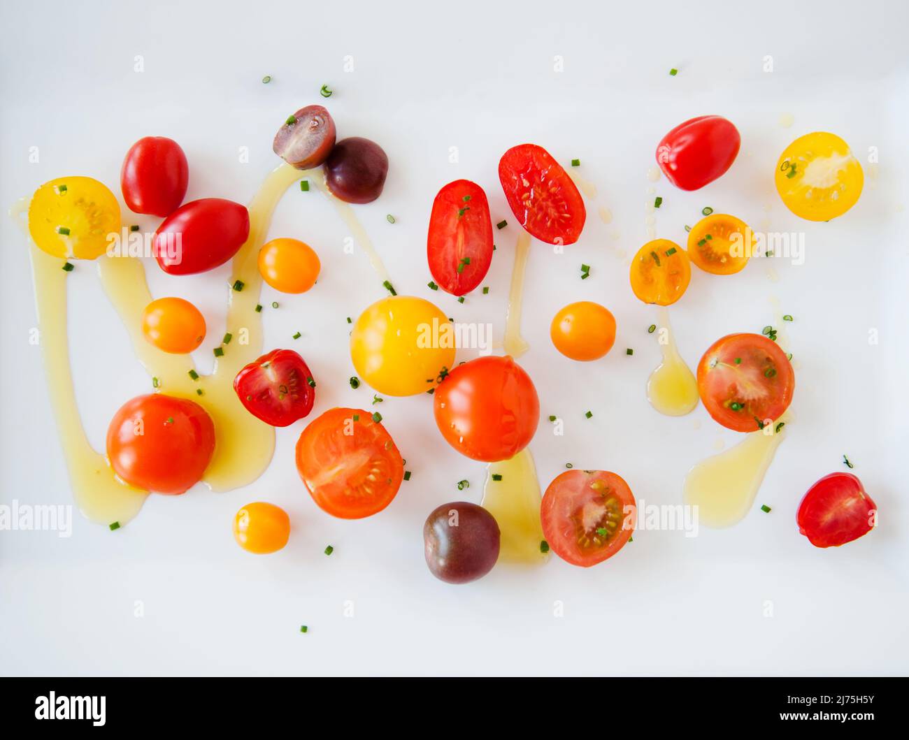 Mixed tomatoes with olive oil and herbs Stock Photo Alamy