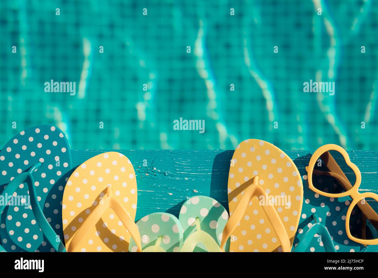 Beach flip-flops and sunglasses on blue wood against water background ...