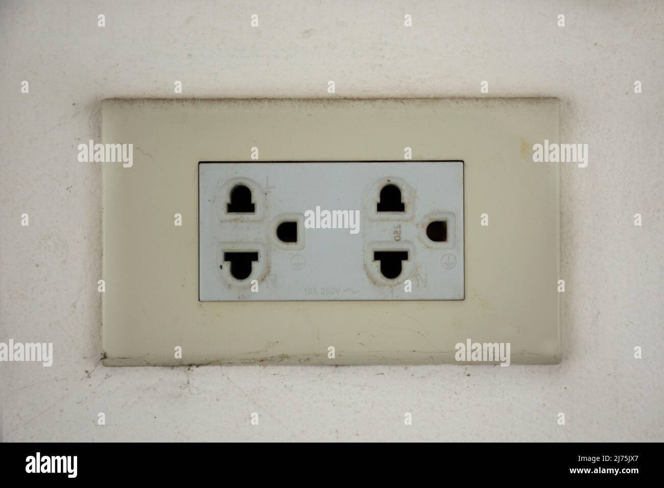 Classic power socket or old electrical outlet on white wall for thai people use energy
