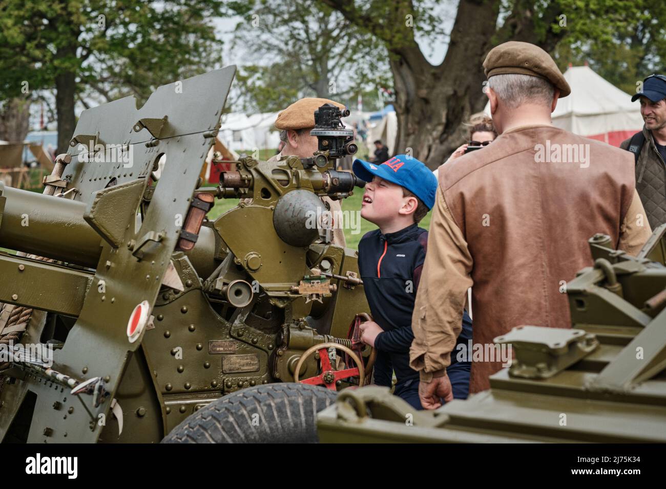 A boy looks down the sight of a 25 Pounder field gun at the No Man's Land Event at Bodrhyddan Hall, Wales Stock Photo
