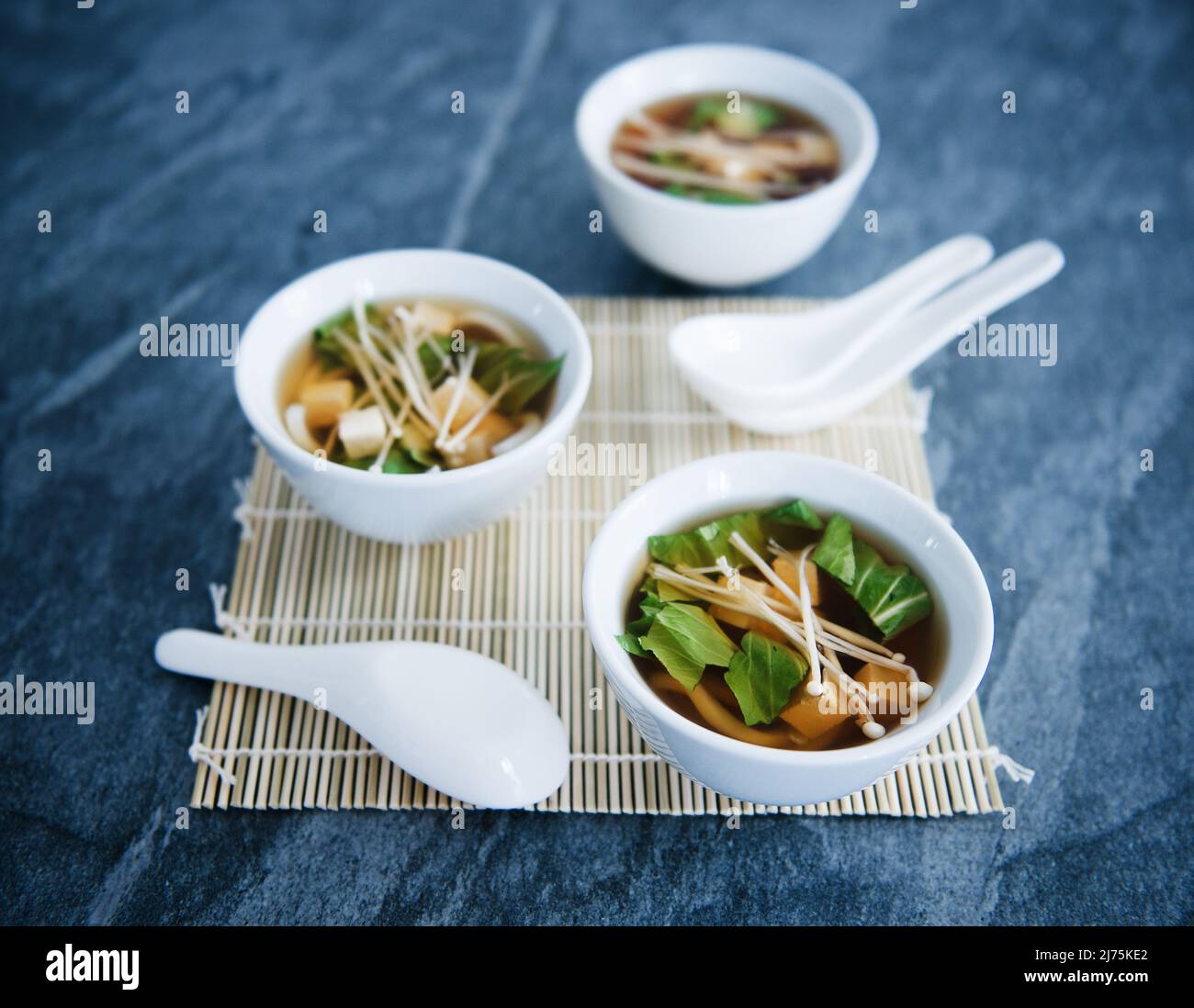 Servings of Asian noodle soup with mushrooms, bok choy, noodles, and mushrooms Stock Photo